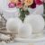 White marble Luminous floor candle holders set against a refined decor backdrop with roses, showcasing versatility and classic charm in home lighting.