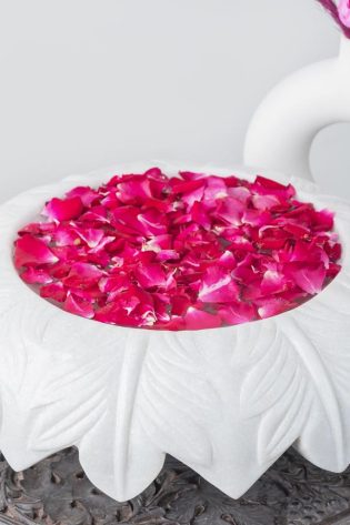 Natural Handicrafts' Fringe Candle Floater with leaf design, filled with pink rose petals and floating candles, offering a romantic and mystical charm.