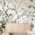 Wallpaper named 'Vineyard' displaying a charming scene of greenery and birds, offering a peaceful and natural touch to a bright and modern room design.