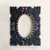 Black carved wood frame mirror with ornate detailing and gold accents, adding a luxurious touch to wall decor.