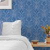 Rich blue Paisley wallpaper with elaborate traditional patterns creating a regal and inviting atmosphere in a contemporary bedroom setting.