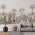 Panoramic view of the 'Desert Pink Sand' wallpaper in a modern living room, depicting a tranquil desert scene with cacti and distant mountains, enveloping the space in warmth and natural beauty.