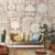 Stylish Geet wallpaper showcasing abstract folk motifs in earthy tones, creating a contemporary yet culturally rich backdrop for a cozy living space with decorative pillows and plants.