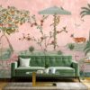 Pastel pink Gulbiya wallpaper gracing the walls of a stylish living area, populated with imagery of deer, monkeys, and flora, creating a tranquil and exotic atmosphere.