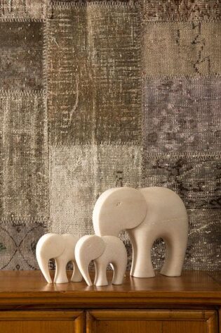 Marble elephant family artefacts by Natural Handicrafts on a textured surface